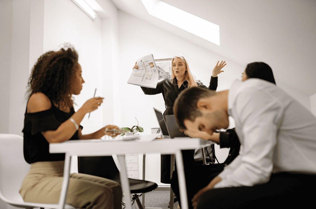 Bad boss frustrated in a meeting with a demotivated team