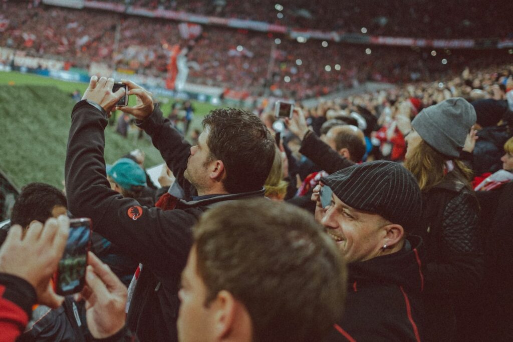 Business Advisor 1 Football fans filming a match on their phones, the audience clubs want a direct relationship with fans